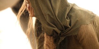 Movie still from “The Witcher” (2019), created by Lauren Schmidt Hissrich – View of a woman's hair and a scarf; Extreme Close Up shot, Over the shoulder angle