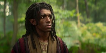 Movie still from “The Witcher” (2019), created by Lauren Schmidt Hissrich – A man with dreadlocks is standing in the woods; Close Up shot, High angle