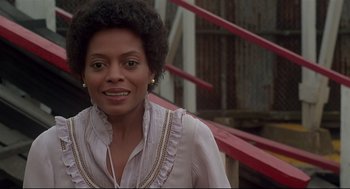 Movie still from “The Wiz” (1978), directed by Sidney Lumet – A black woman with a white shirt is smiling for the camera; Close Up shot, Low angle