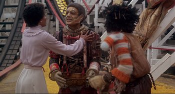 Movie still from “The Wiz” (1978), directed by Sidney Lumet – A man in a costume is being hugged by a woman; Medium shot, Over the shoulder angle