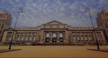 Movie still from “The Wiz” (1978), directed by Sidney Lumet – A large building that has many windows on it's side; Extreme Wide shot, Low angle