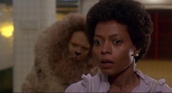 Movie still from “The Wiz” (1978), directed by Sidney Lumet – A woman standing in front of a man with a fake lion; Close Up shot, Over the shoulder angle