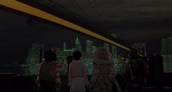 Movie still from “The Wiz” (1978), directed by Sidney Lumet – A group of people standing in front of a city at night; Extreme Wide shot, Low angle