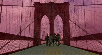 Movie still from “The Wiz” (1978), directed by Sidney Lumet – A group of people standing on top of a red bridge; Wide shot, Low angle