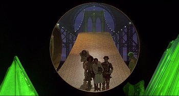 Movie still from “The Wiz” (1978), directed by Sidney Lumet – A group of people standing in front of a bridge at night; Wide shot, High angle