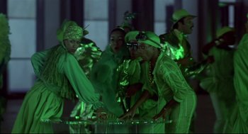 Movie still from “The Wiz” (1978), directed by Sidney Lumet – A group of people dressed in green are standing in a circle; Medium shot, Low angle
