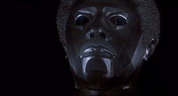 Movie still from “The Wiz” (1978), directed by Sidney Lumet – A metal sculpture of a man's face in the dark; Close Up shot, Low angle