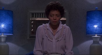 Movie still from “The Wiz” (1978), directed by Sidney Lumet – A woman in a white shirt is standing in front of a window; Medium shot, Low angle