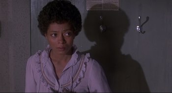 Movie still from “The Wiz” (1978), directed by Sidney Lumet – A woman in a white shirt is standing in a room; Close Up shot, Over the shoulder angle
