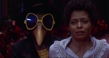 Movie still from “The Wiz” (1978), directed by Sidney Lumet – A woman standing next to a person wearing a bird mask; Close Up shot, Low angle