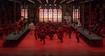 Movie still from “The Wiz” (1978), directed by Sidney Lumet – A large group of people in a red room; Extreme Wide shot, High angle