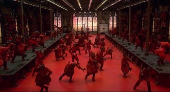 Movie still from “The Wiz” (1978), directed by Sidney Lumet – A group of people dressed in red dance in front of a window; Extreme Wide shot, High angle