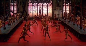Movie still from “The Wiz” (1978), directed by Sidney Lumet – A group of people are dancing on a red floor; Extreme Wide shot, High angle