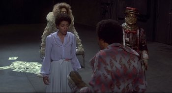 Movie still from “The Wiz” (1978), directed by Sidney Lumet – A woman standing next to a man wearing a fur coat; Medium shot, Over the shoulder angle
