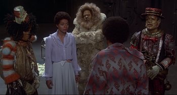 Movie still from “The Wiz” (1978), directed by Sidney Lumet – A group of people standing next to each other in a room; Medium shot, Over the shoulder angle