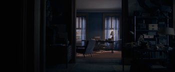 Movie still from “The Woman in the Window” (2021), directed by Joe Wright – A living room with a chair and a desk in it; Wide shot, High angle