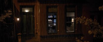 Movie still from “The Woman in the Window” (2021), directed by Joe Wright – A man standing in front of an open window in a room; Extreme Wide shot, High angle