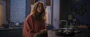 Movie still from “The Woman in the Window” (2021), directed by Joe Wright – A woman standing in front of a kitchen counter; Medium shot, Over the shoulder angle