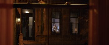 Movie still from “The Woman in the Window” (2021), directed by Joe Wright – A man standing in front of a window at night; Extreme Wide shot, Over the shoulder angle