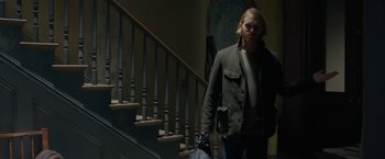 Movie still from “The Woman in the Window” (2021), directed by Joe Wright – A man with a bag walking down the stairs; Medium shot, Low angle