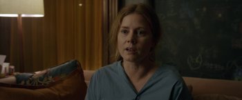 Movie still from “The Woman in the Window” (2021), directed by Joe Wright – A woman in a blue shirt is looking at the camera; Close Up shot, Over the shoulder angle