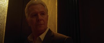 Movie still from “The Woman in the Window” (2021), directed by Joe Wright – An older man in a brown suit and white shirt; Close Up shot, Low angle