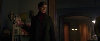 Movie still from “The Woman in the Window” (2021), directed by Joe Wright – A woman standing in a dark room wearing a black coat; Medium shot, Over the shoulder angle