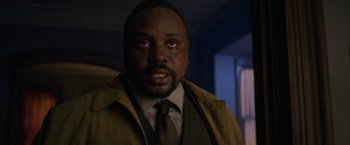 Movie still from “The Woman in the Window” (2021), directed by Joe Wright – A man in a brown jacket and a brown tie; Close Up shot, Over the shoulder angle