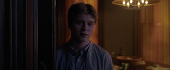 Movie still from “The Woman in the Window” (2021), directed by Joe Wright – A young man standing in front of a mirror in a room; Close Up shot, Over the shoulder angle