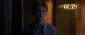 Movie still from “The Woman in the Window” (2021), directed by Joe Wright – A young man is standing in front of a window; Close Up shot, Over the shoulder angle