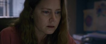 Movie still from “The Woman in the Window” (2021), directed by Joe Wright – A person with long brown hair; Close Up shot, Over the shoulder angle