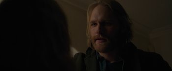 Movie still from “The Woman in the Window” (2021), directed by Joe Wright – A person with long hair and a beard; Close Up shot, Over the shoulder angle