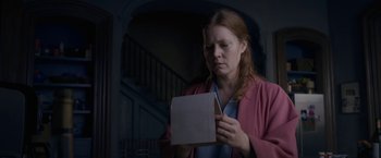 Movie still from “The Woman in the Window” (2021), directed by Joe Wright – A woman holding a piece of paper in her hands; Close Up shot, Low angle