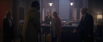Movie still from “The Woman in the Window” (2021), directed by Joe Wright – A man and a woman standing in front of a counter; Wide shot, Over the shoulder angle
