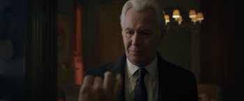 Movie still from “The Woman in the Window” (2021), directed by Joe Wright – An older man in a suit and a tie; Close Up shot, Over the shoulder angle