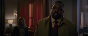 Movie still from “The Woman in the Window” (2021), directed by Joe Wright – A man in a suit and tie standing in front of a window; Close Up shot, Over the shoulder angle