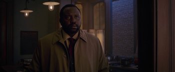 Movie still from “The Woman in the Window” (2021), directed by Joe Wright – A man wearing a brown jacket and a red tie; Close Up shot, Over the shoulder angle