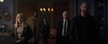 Movie still from “The Woman in the Window” (2021), directed by Joe Wright – A group of people standing around in a room; Medium shot, Low angle