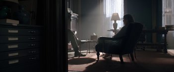 Movie still from “The Woman in the Window” (2021), directed by Joe Wright – A living room filled with furniture and a lamp; Wide shot, Low angle