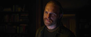 Movie still from “The Woman in the Window” (2021), directed by Joe Wright – A person with a beard looking at the camera; Close Up shot, Over the shoulder angle