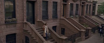 Movie still from “The Woman in the Window” (2021), directed by Joe Wright – A woman walking down the steps of a building; Extreme Wide shot, High angle