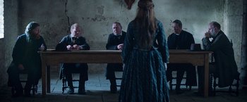 Movie still from “The Wonder” (2022), directed by Sebastián Lelio – A group of people sitting around a table; Medium shot, Over the shoulder angle