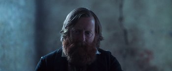 Movie still from “The Wonder” (2022), directed by Sebastián Lelio – A man with long hair and a red beard; Close Up shot, Low angle