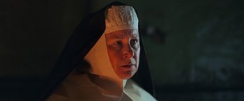 Movie still from “The Wonder” (2022), directed by Sebastián Lelio – An older woman wearing a nun's hat and looking at the camera; Close Up shot, Low angle