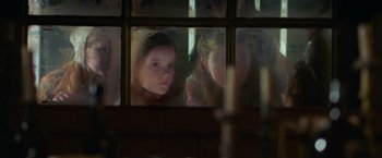 Movie still from “The Wonder” (2022), directed by Sebastián Lelio – Two young girls looking out of a window at a candle; Close Up shot, Over the shoulder angle