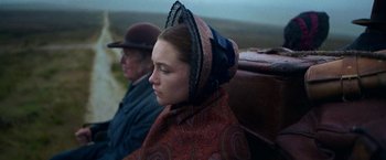 Movie still from “The Wonder” (2022), directed by Sebastián Lelio – A young woman wearing an old fashion hat; Close Up shot, Over the shoulder angle