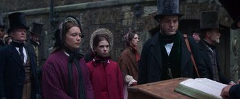 Movie still from “The Wonder” (2022), directed by Sebastián Lelio – A group of people dressed in period clothing; Medium shot, Low angle