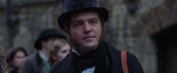 Movie still from “The Wonder” (2022), directed by Sebastián Lelio – A person wearing a top hat; Close Up shot, Over the shoulder angle