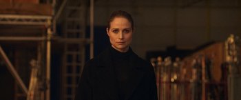 Movie still from “The Wonder” (2022), directed by Sebastián Lelio – A woman in a black coat standing next to a fence; Close Up shot, Low angle