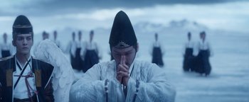 Movie still from “The Yin-Yang Master: Dream of Eternity” (2020), directed by Jingming Guo – A man in traditional korean clothing praying in front of a group of people; Medium shot, Low angle